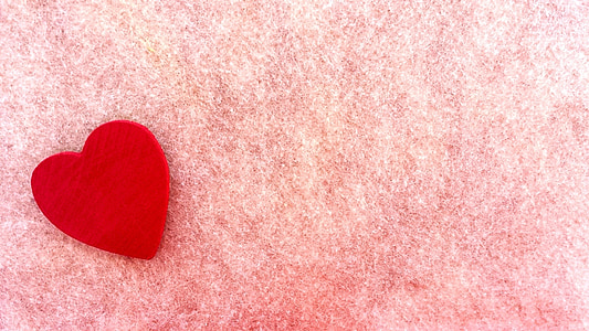red heart ornament on top of pink textile thumbnail