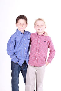 two boys in red and blue button-up sport shirts and denim pants thumbnail