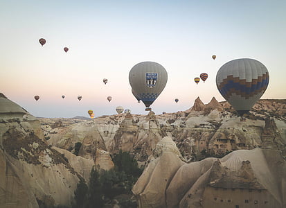 hot air balloon flying over brown sculptures thumbnail