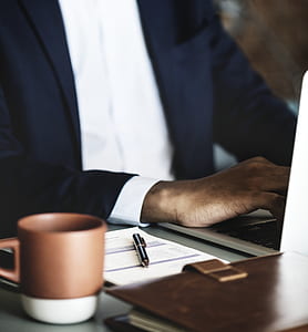 man working on laptop near brown coffee table on brown wooden desk thumbnail