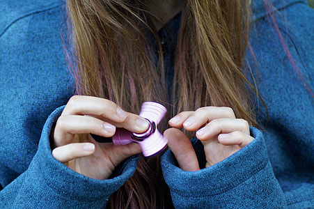 person holding purple 3-lobed fidget spinner thumbnail