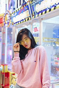 woman wearing Champion pink sweater taking photo inside the mall thumbnail