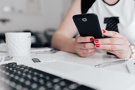 Businesswoman uses her mobile phone at her desk thumbnail