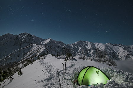 green camping tent on top of snow mountain thumbnail
