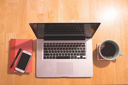 MacBook Pro beside white ceramic mug and silver iPhone 6 thumbnail