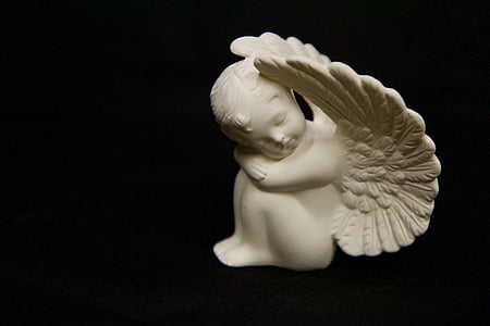 closeup photography of white cherub ceramic figurine thumbnail
