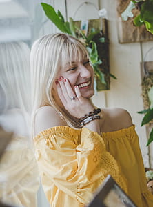 woman smiling while touching her cheek thumbnail
