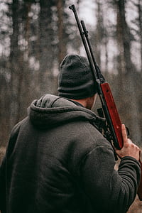 man holding hunting rifle thumbnail