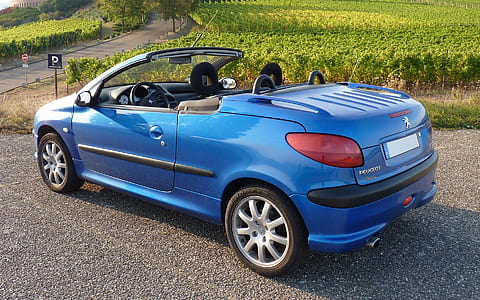blue Peugeot convertible coupe parked near green grass field thumbnail