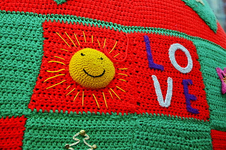 close-up of red and green love-embroidered crochet garment thumbnail