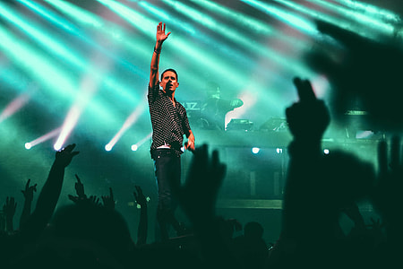 man raising his right hand over crowd of people thumbnail