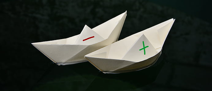 two white paper boats on body of water thumbnail