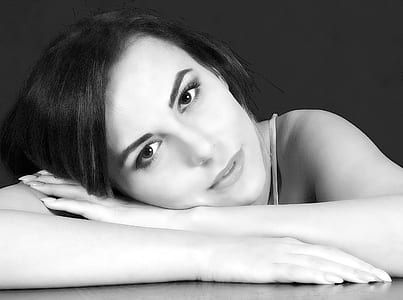 grayscale photography of woman leaning on table thumbnail