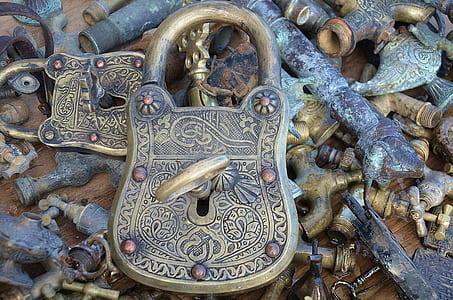 vintage brass-colored padlock with key on faucet with pipes thumbnail