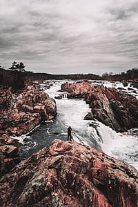 man on rock near on waterfalls thumbnail