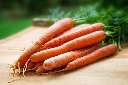 shallow focus photography of carrots on top of chopping board thumbnail