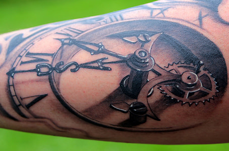 close-up photography of human arm with mechanical clock tattoo thumbnail