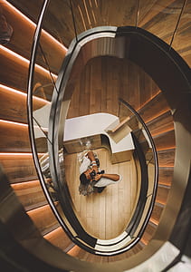 man holding DSLR camera taking picture in spiral foot stairs thumbnail