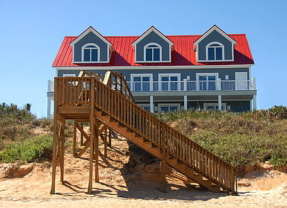 brown wooden ladder in front of blue house thumbnail