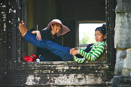 two women sitting and lying on concrete window thumbnail