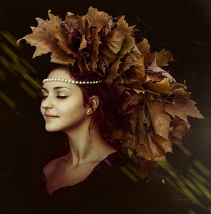 woman in black v-neck shirt and brown leaf headdress thumbnail