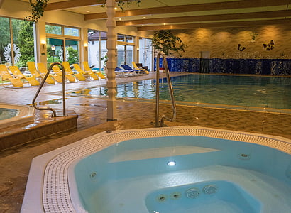 jetted hot tub beside pool inside building thumbnail