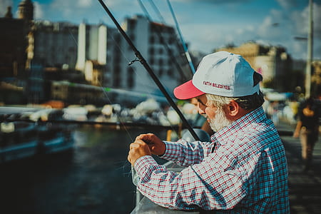 man holding fishing rod wearing white cap thumbnail