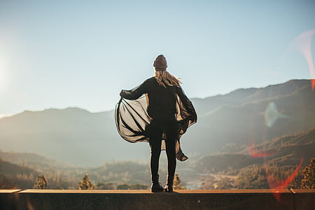 woman standing on rail seeing hills thumbnail