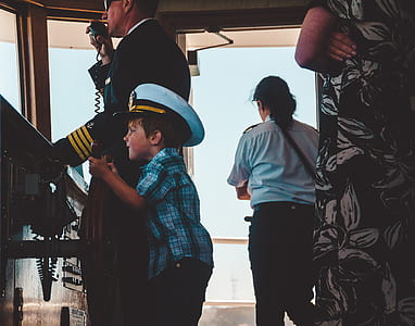 man holding ship's wheel beside the captain thumbnail