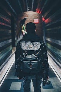 shallow focus photography of person carrying backpack and DSLR camera thumbnail