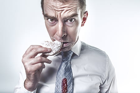man wearing gray dress shirt eating a cookie thumbnail