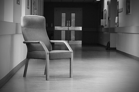 grayscale photo of armchair beside window thumbnail