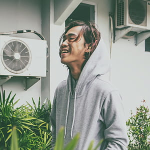 Man Laughing While Standing Near Plants thumbnail