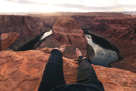 person sitting beside Horseshoe Bend in Arizona during daytime thumbnail