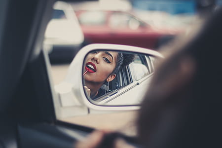 selective focus photography of vehicle side mirror reflecting woman in red lipstick thumbnail