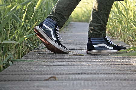 person wearing pair of black Vans OS thumbnail