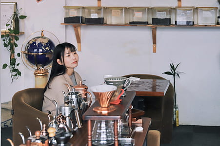 woman sitting on chair beside coffee mugs thumbnail
