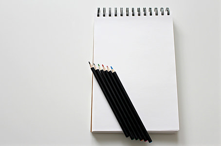 five assorted-color color pens on white spiral notebook thumbnail