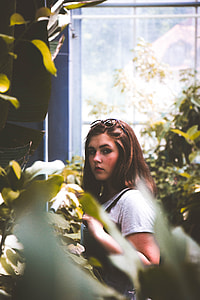woman wearing gray shirt standing near green leaf plant during daytime thumbnail