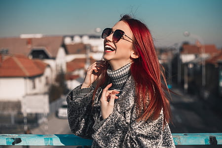 laughing woman wearing sunglasses and grey and black turtle-neck sweater thumbnail