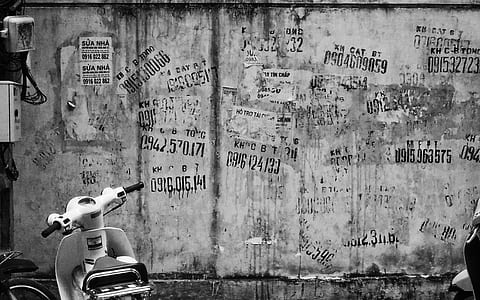 grayscale photo of graffiti wall near parked scooter thumbnail