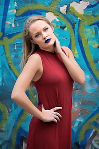 woman holding her neck standing in front of blue and green wall thumbnail