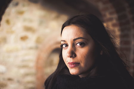 woman wearing black top standing near brown brick wall closeup photography thumbnail
