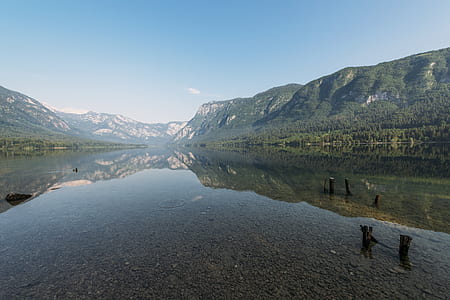 calm river near mountain under white cloud and blue skies thumbnail