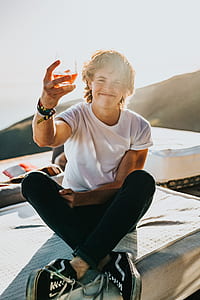 man smiling while holding a glass of liquor thumbnail
