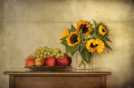 sunflower arrangement near bunch of fruits on brown wooden table thumbnail