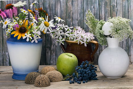 assorted-color flowers in vase on brown wooden surface thumbnail