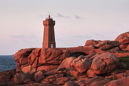 gray tower near cliff on body of water thumbnail