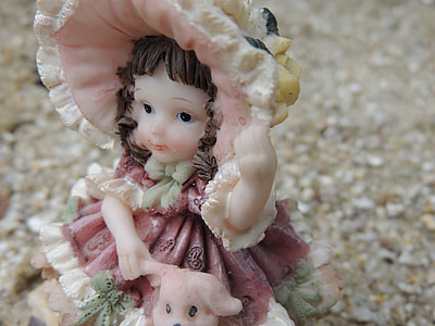 selective focus photo of ceramic girl wearing hat and red dress thumbnail