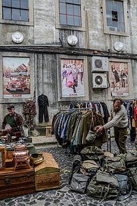 man holding bag beside concrete building thumbnail